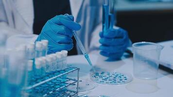 Scientists analyzing coronavirus study data and evaluating microscope. Health care researchers doing some research virus with dropper chemical testing and working in life science laboratory. video