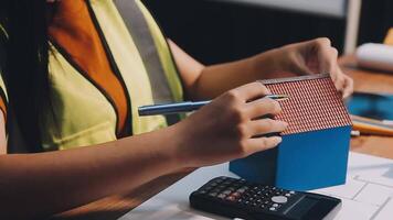 Selective focus, Asian female architect or engineer Currently considering materials for designing modern condominiums. Asian female architect or engineer Sit and analyze, design projects in the office video