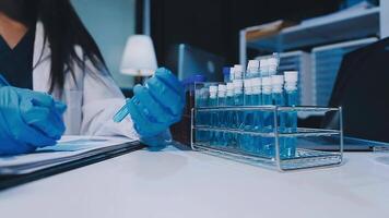 Scientists analyzing coronavirus study data and evaluating microscope. Health care researchers doing some research virus with dropper chemical testing and working in life science laboratory. video