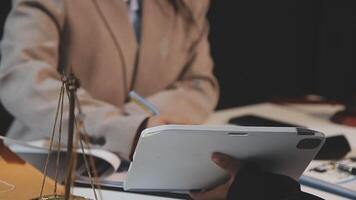 justice and law concept. asian woman lawyer working and judge in a courtroom the gavel, working with tablet and laptop and digital tablet computer on white table video