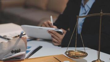 justice and law concept. asian woman lawyer working and judge in a courtroom the gavel, working with tablet and laptop and digital tablet computer on white table video