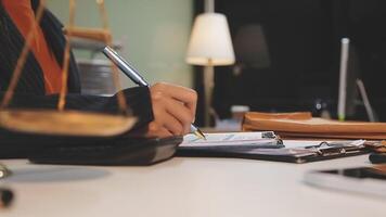 justice and law concept. asian woman lawyer working and judge in a courtroom the gavel, working with tablet and laptop and digital tablet computer on white table video