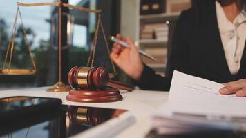 justice and law concept. asian woman lawyer working and judge in a courtroom the gavel, working with tablet and laptop and digital tablet computer on white table video