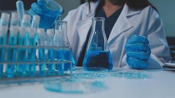 chemist,scientist hand dropping chemical liquid into test tube, science research and development concept video