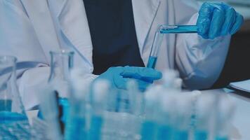 chemist,scientist hand dropping chemical liquid into test tube, science research and development concept video