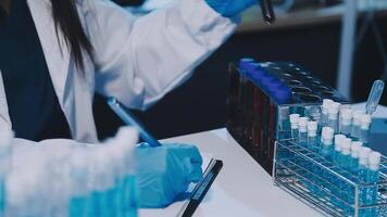 Scientists analyzing coronavirus study data and evaluating microscope. Health care researchers doing some research virus with dropper chemical testing and working in life science laboratory. video