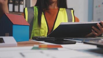 Selective focus, Asian female architect or engineer Drawing the design of the building's interior using a tablet. Asian female architect or engineer Sit and analyze, design projects in the office. video