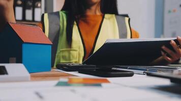 Selective focus, Asian female architect or engineer Currently considering materials for designing modern condominiums. Asian female architect or engineer Sit and analyze, design projects in the office video