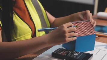 Selective focus, Asian female architect or engineer Drawing the design of the building's interior using a tablet. Asian female architect or engineer Sit and analyze, design projects in the office. video