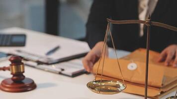 justice and law concept. asian woman lawyer working and judge in a courtroom the gavel, working with tablet and laptop and digital tablet computer on white table video
