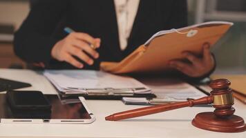 justice and law concept. asian woman lawyer working and judge in a courtroom the gavel, working with tablet and laptop and digital tablet computer on white table video