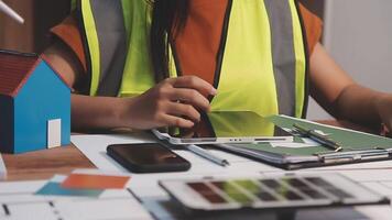 Selective focus, Asian female architect or engineer Drawing the design of the building's interior using a tablet. Asian female architect or engineer Sit and analyze, design projects in the office. video