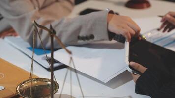 justice and law concept. asian woman lawyer working and judge in a courtroom the gavel, working with tablet and laptop and digital tablet computer on white table video