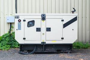 auxiliary diesel generator for emergency power supply. Industrial generator connected to the control panel by a cable wire. Backup power supply of the generator photo