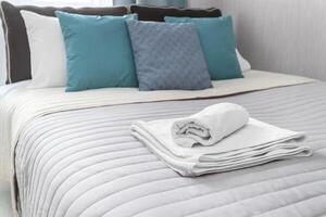 Towels lie on the bed with colorful pillows photo
