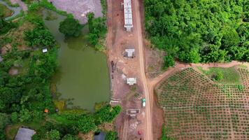 Aerial view of a new road development or highway under construction. Top view from a drone over road construction workers amidst mountains. Construction Site with Cranes and Heavy Equipment. video