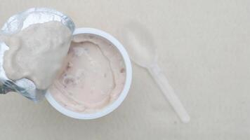 fresh yogurt in a plastic container and spoon on table video