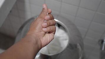 Hand discards torn paper towels into bathroom trash can, showing cleanliness and waste disposal video