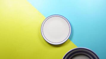 top view of putting plates on a color background video