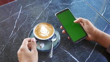 holding a cpu of coffee and using smart phone with green screen video