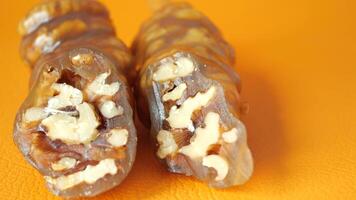 Closeup of a sweet treat made with walnuts and grape molasses, on an orange background video