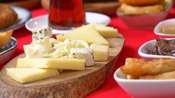 A rustic cheese board featuring an assortment of cheeses displayed on a wooden platter video