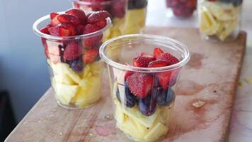 pineapple, kiwi and Strawberries in. plastic container selling at shop video