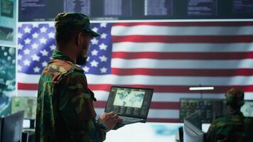 US soldiers operating in a high tech cybersecurity command post, managing state secrets and classified information. Protecting servers against digital threats and cyber warfare. Camera B. video