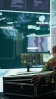 Vertical Army espionage specialist in a control center collecting satellite cctv data real time surveillance, strategic military operations. Working to ensure national security and protocols. Camera B. video