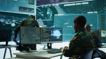 Programming engineer soldier handles AI brain and deep learning data on computer in command post, coordinates national defense operations. Neural network artificial intelligence science. Camera B. video