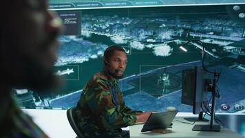 Soldiers in a modern command center analyze live data from cctv radar sources, satellite feeds and surveillance systems. Intelligence to support strategic planning and military operations. Camera B. video