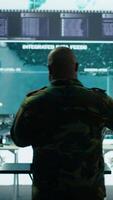 Vertical Military specialist in command post uses advanced technology and high tech gear to gather intelligence from satellite imagery and computer surveillance systems to communicate information. Camera B. video