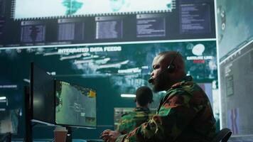 Military control room features army personnel monitoring surveillance systems, soldiers integrating data and coordinating strategic missions. Support decision making and efficiency. Camera B. video
