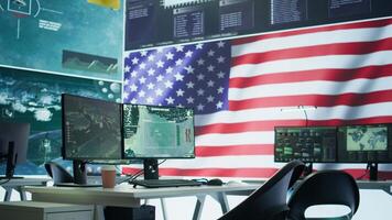 Empty operation room with an American flag running on big screen in control tower, protecting classified information and state secrets. Military command post fights for anti terrorism. Camera B. video
