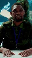 Vertical Military intelligence expert conducts a strategic teleconference connection in a modern command post, utilizing real time data on multiple screens for communication and decision making. Camera A. video