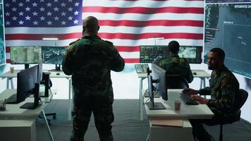 Team of military experts operates high tech computers and tablet to analyze surveillance data and manage national security operations. Working with CCTV radar satellite imagery. Camera B. video