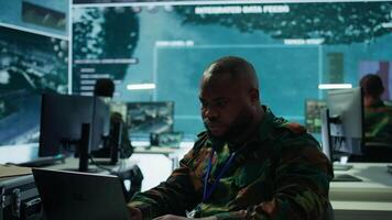 Military intelligence specialist uses high tech satellite systems and cctv radar to ensure national protocols, strategic missions for defense operation in command post control tower. Camera B. video