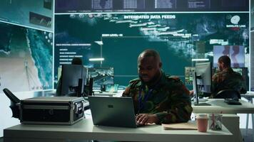 Army intelligence expert utilizes modern computer systems and satellite radar imagery to enhance national security, strategic initiatives and ensure defense in mission control center. Camera B. video