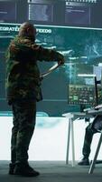 Vertical Military team operating in a high tech command post control tower, focusing on surveillance tactics for intelligence gathering. Data protection to manage critical information operations. Camera B. video