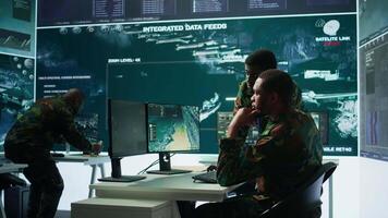 IT analyst managing satellite radar systems in modern control tower, overseeing intelligence activities and interpreting real time data. National interests for a defense mission. Camera B. video