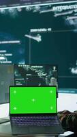 Vertical IT expert collecting real time information next to isolated chroma key screen, high tech gear in command post. Soldier processing intelligence for field operations and strategic missions. Camera B. video