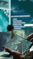Vertical Military officer leads cybersecurity operations in a high tech operation room command post, ensuring data protection. Soldiers working with cctv surveillance systems, satellite imagery. Camera B. video