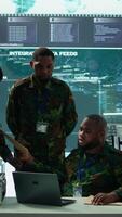 Vertical Military personnel in a modern command center handle critical information, collecting live surveillance data to maintain security protocols. Team of army crew working on reconnaissance. Camera B. video