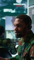 Vertical Army intelligence specialist utilize advanced computer systems, surveillance technology and data to enhance national security. Working in a command post against potential threats. Camera B. video