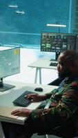 Vertical Army intelligence specialists using advanced computer systems and satellite data to enhance national security, critical information. Soldiers planning for mission in high tech control room. Camera B. video