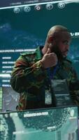 Vertical Military officer leads cybersecurity efforts in a high tech control center, ensuring data protection and managing surveillance systems, Coordinating national security operations. Camera B. video