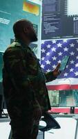 Vertical Angry army expert in a command post power base monitors satellite footage, yelling at soldier and throwing papers. Frustrated officer looks at real time data for operational success. Camera B. video