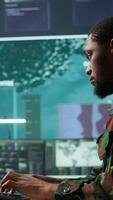 Vertical IT expert monitors AI brain intelligence system to collect crucial real time data for a new defense military operation on pc in command post. Security protocols for an intense mission. Camera B. video