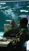 Vertical Team of military specialists in command post monitoring satellite data, integrates real time information from cctv footage. Decision making for strategic defense missions and security. Camera B. video