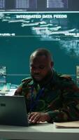 Vertical Army intelligence expert utilizes modern computer systems and satellite radar imagery to enhance national security, strategic initiatives and ensure defense in mission control center. Camera B. video